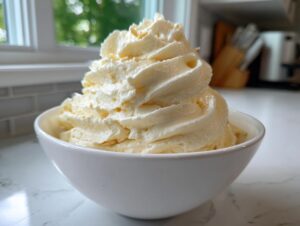 A generous swirl of creamy, pale yellow banana ice cream served in a white bowl.