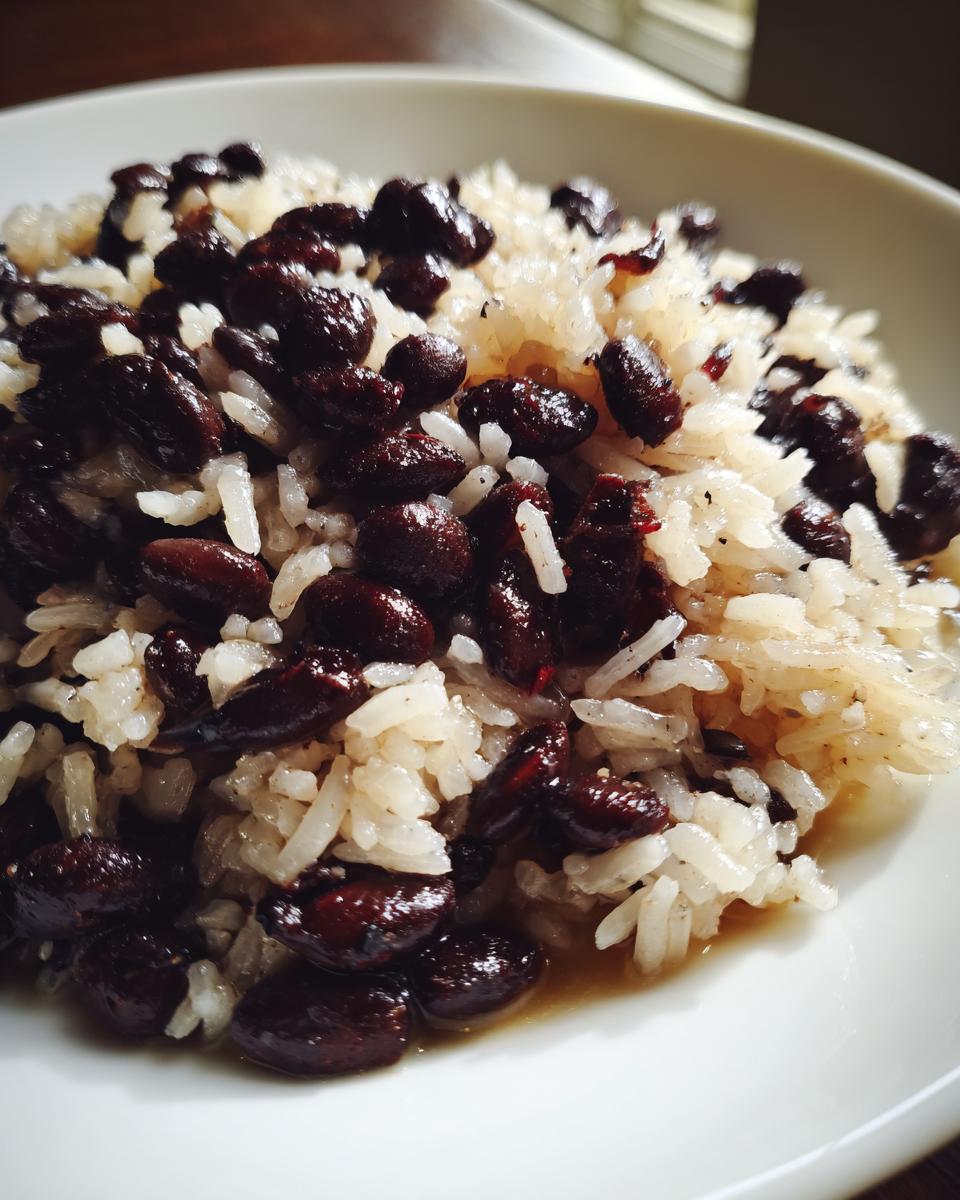 Close-up of a serving of flavorful beans and rice, featuring dark red kidney beans mixed with white rice.