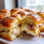 Close-up of Ham and Cheese Sliders pulled apart showing gooey melted cheese and ham inside the poppy seed buns.