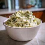 A generous serving of amazing 5 minute dill dip, loaded with fresh herbs, mounded in a white bowl.