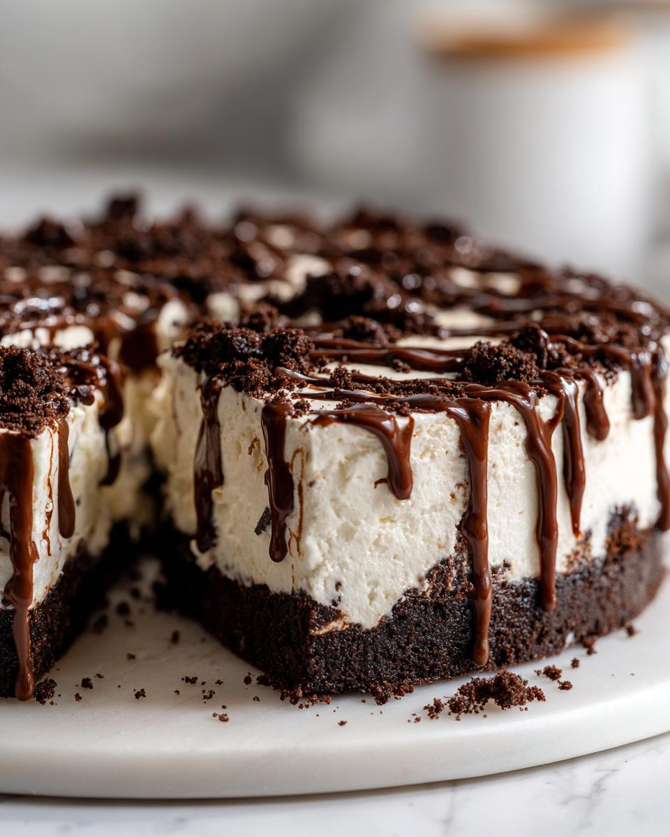 A decadent Baileys Chocolate Cheesecake Trifle with a thick chocolate crust and creamy white filling, drizzled with chocolate sauce.