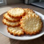 A stack of freshly baked, golden-edged sugar cookie cutouts with a slightly textured top.