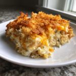 A close-up serving of creamy chicken and wild rice casserole with a crispy, golden brown topping.