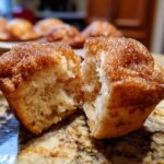 A cinnamon sugar french toast muffin broken in half showing the soft, fluffy interior and sugary topping.