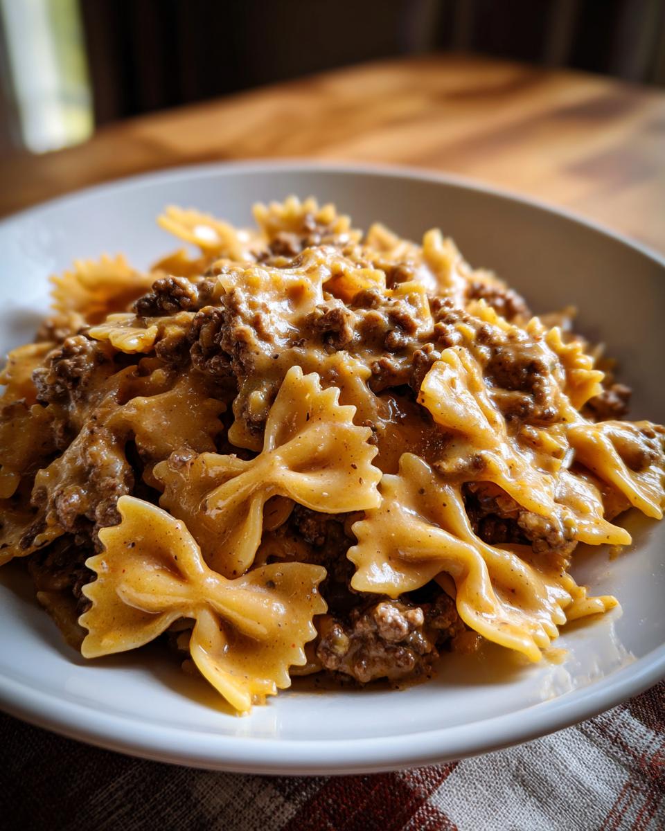Close-up of creamy parmesan garlic beef bowtie pasta coated in a rich, savory sauce.