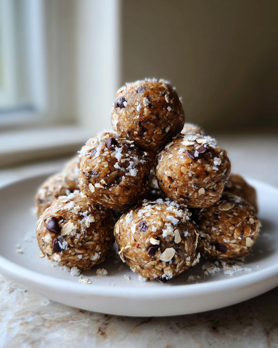 A pyramid stack of delicious homemade protein balls coated in oats and shredded coconut.