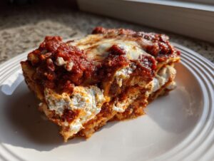 A generous slice of Instant Pot Lasagna showing layers of pasta, rich meat sauce, and creamy white ricotta cheese.