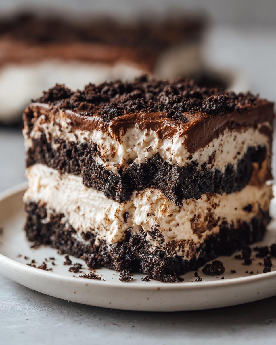 Close-up of a layered slice of Oreo dirt cake showing chocolate cookie layers and creamy filling.
