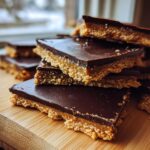 Close-up stack of homemade graham cracker toffee bars showing the crunchy base and smooth chocolate top layer.