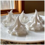 Five perfectly piped white royal icing peaks, ideal for gingerbread house icing glue.