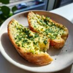 Two slices of toasted bread generously topped with melted garlic butter and fresh chopped parsley.