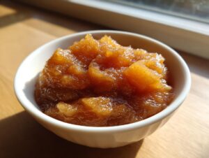 Close-up of chunky, spiced homemade applesauce served in a small white bowl.
