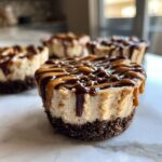 Close-up of one of the cookie butter cheesecake cups topped with caramel and chocolate drizzle.
