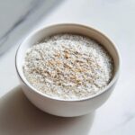 Close-up of creamy chia seed pudding topped with extra seeds in a white bowl.