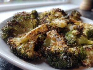Close-up of perfectly roasted and slightly charred smashed broccoli florets seasoned with cheese.