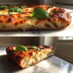 Cross-section showing the airy, thick texture of a perfect keto pizza crust topped with melted cheese and basil.