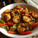 Close-up of perfectly seasoned shrimp fajitas with colorful bell peppers and onions in a white bowl.