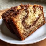 Close-up of two moist slices of snickerdoodle zucchini bread featuring a cinnamon swirl topping and crumb.