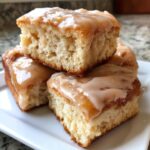 Close-up of three stacked, soft maple donut bars topped with a thick, dripping maple glaze.