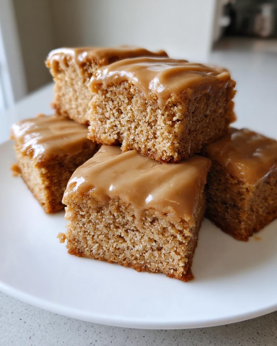Close-up of stacked maple donut bars with thick, glossy maple glaze on a white plate.