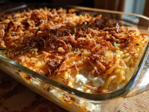 Close-up of a creamy Monterey Chicken Spaghetti casserole topped with crispy fried onions.